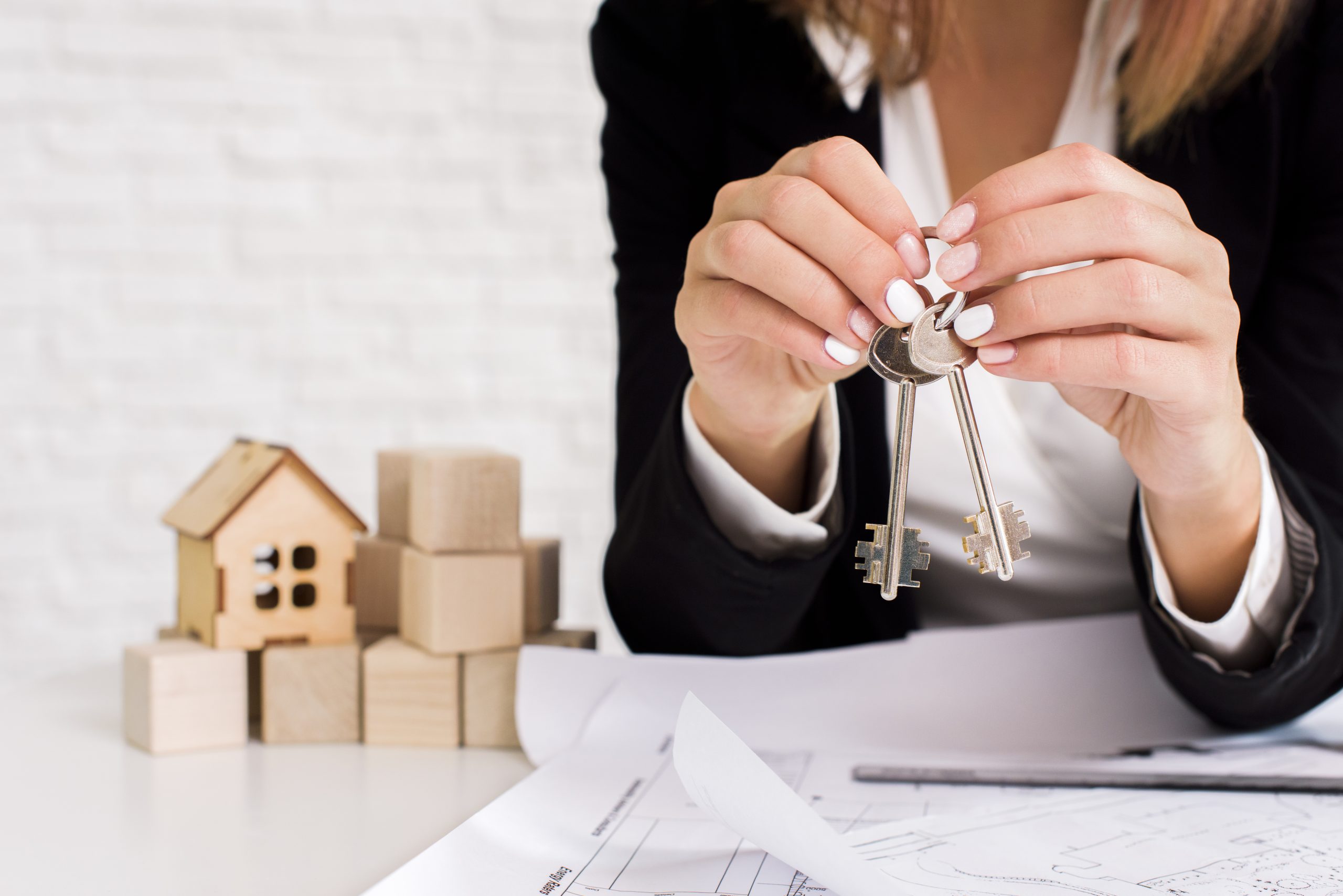 woman-holding-set-keys-with-wooden-cubes
